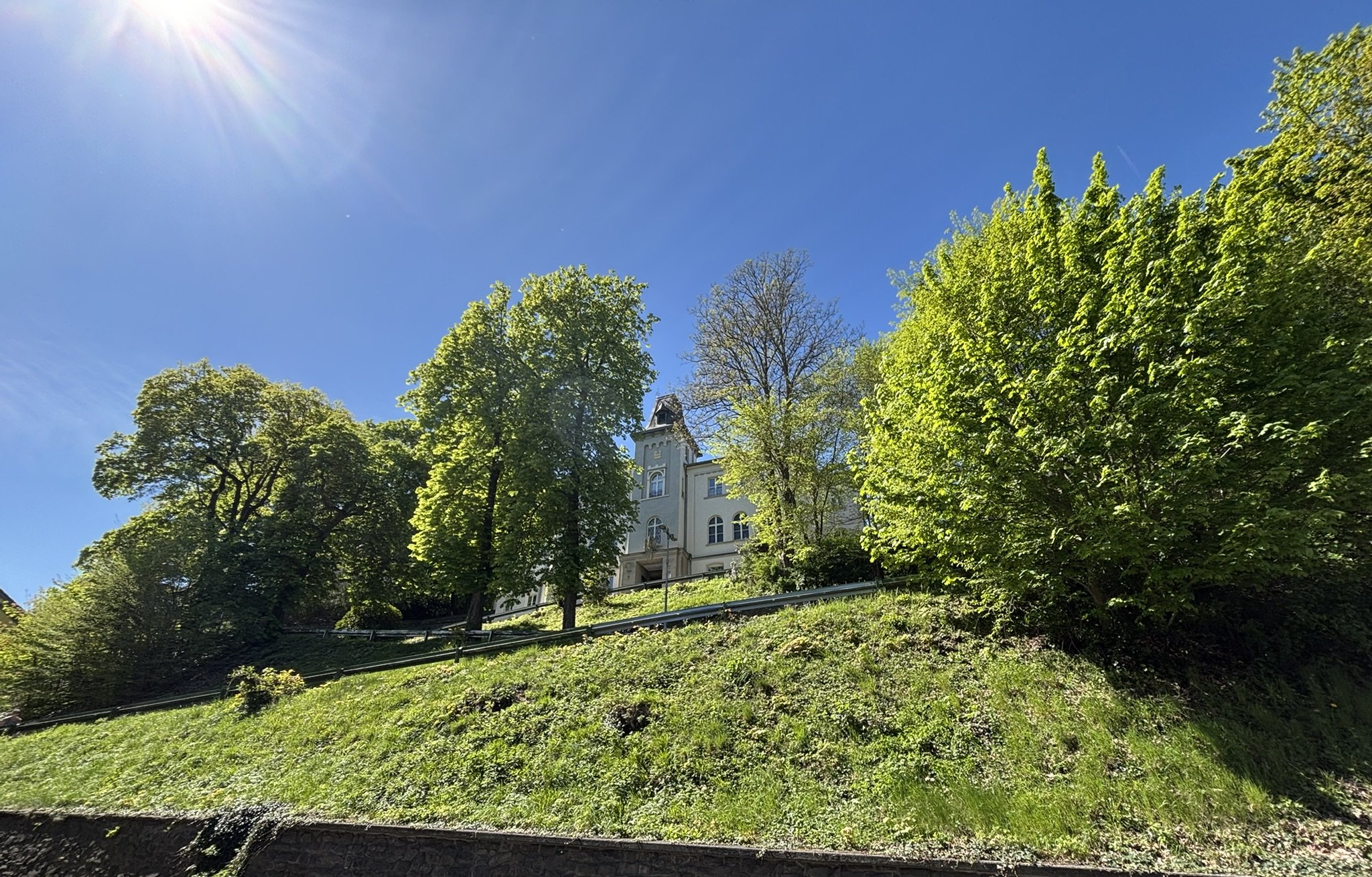 Bild des Rathauses der Stadt Altena, von der Lüdenscheider Straße aus, im Sonnenschein bei blauem Himmel.