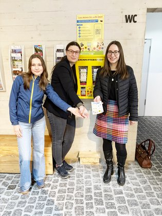 Bild von der Einweihung des Bienenfutterautomats im Foyer des Erlebnisaufzugs. V.l.n.r.: Praktikantin Malya Tymoszuk, Julia Kaiser und Anke Borscheid.