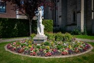 Denkmal der Heldin von Péronne, Marie Fouré, in der französischen Partnerstadt Altenas. Eine weiße Statue einer Frau, umringt von einem kreisrunden Blumenbeet.