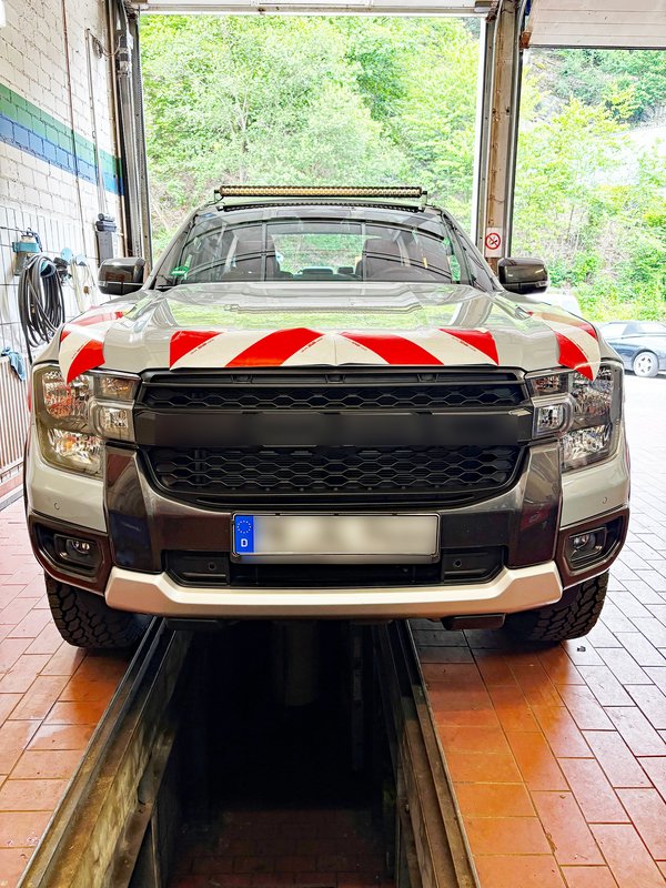 Ein Ford Ranger Fahrzeug in silber, aufgenommen von vorne in einer Halle.